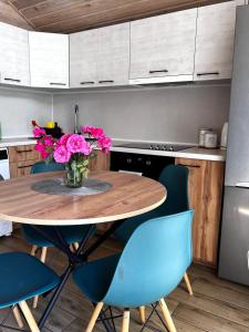 une cuisine avec une table en bois et des chaises bleues dans l'établissement Treeskit House, à Horenka