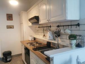 una cocina con armarios blancos y fregadero en Kúria Apartman Budapest with free parking en Budapest