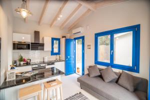 a kitchen and living room with blue doors and a couch at ONIRO Villas in Stavros