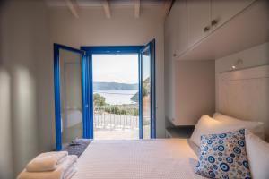 a bedroom with a bed and a door to a balcony at ONIRO Villas in Stavros