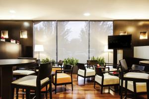 a restaurant with tables and chairs and a flat screen tv at Ibis Barcelona Molins de Rei in Molins de Rei