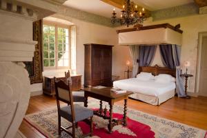 Schlafzimmer mit einem Bett, einem Schreibtisch und einem Bett in der Unterkunft Le château de Bonnemare - Bed and breakfast in Radepont