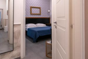 a bedroom with a bed with a blue bedspread at Hotel San Michele in Naples