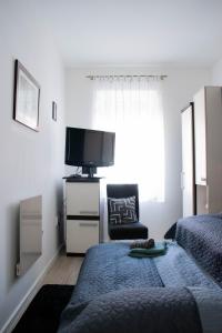 a bedroom with a bed and a tv and a chair at Apartman Agata,Osijek, self check-in in Osijek +34 photos