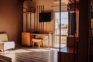 a living room with a tv and a table and a chair at Hotel Maggio in Malargüe