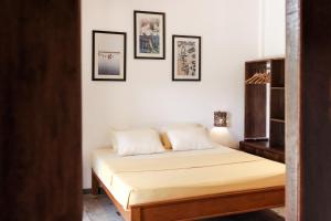 a bed in a room with three pictures on the wall at Stay Golden in Arugam Bay