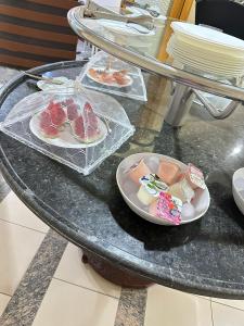a table with two plates of food on it at Hotel Central Plaza Timóteo in Timóteo
