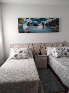 sypialnia z dwoma łóżkami i obrazem na ścianie w obiekcie apartment garden w mieście Caldas de Reis
