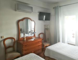 クアルテイラにあるOne bedroom apartement with city view furnished terrace and wifi at Quarteiraのベッドルーム(鏡付きドレッサー、ベッド付)