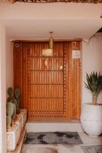 a wooden door with a potted plant in front of it at Riad Dar Blanche & Spa in Marrakech