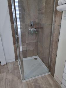 La salle de bains est pourvue d'une douche avec une porte en verre. dans l'établissement Montfort Cottage Guest House, à Windermere
