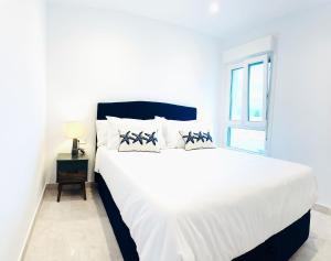 a white bed in a white bedroom with a window at Sunrise by ON Travel in Oliva +22 photos