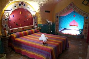 a bedroom with a bed with a rock wall at Casas Cueva Cazorla in Hinojares