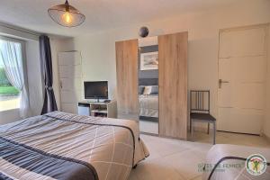 a bedroom with a bed and a desk with a television at La vieux ville in Trégomeur