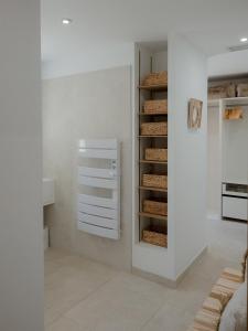 a white room with a closet with bread at La Perle Rose Villa Standing 5 étoiles avec piscine jacuzzi et superbe vue in Aigues-Mortes