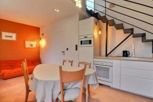 een keuken met een tafel en stoelen en een trap bij Studio naturel lanwezou in Saint-Benoît-des-Ondes