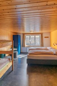 1 dormitorio con 2 camas y techo de madera en Eiger Lodge Easy, en Grindelwald