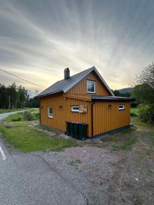un pequeño edificio de madera al lado de una carretera en Svarstad, en Svarstad
