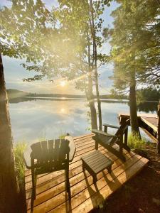 two chairs and a bench on a wooden dock next to a lake at Pine Brae Eco-Resort in Perth +26 photos