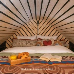 a bed in a yurt with a book and some food at The Mini Stylish Getaway in Corsley