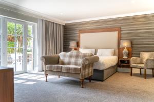 um quarto com uma cama e uma cadeira em Dunadry Hotel And Gardens em Antrim