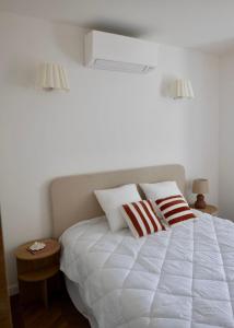a white bed with two pillows on top of it at Liviamariasanta in Ajaccio