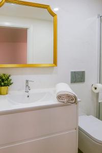a bathroom with a sink and a mirror and a toilet at Green Charm House Lisbon in Lisbon
