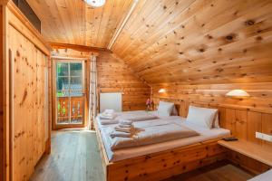 sypialnia z 2 łóżkami w drewnianym pokoju w obiekcie Almwelt Austria w Schladming