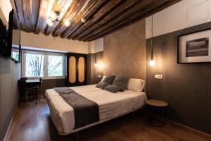 sypialnia z dużym łóżkiem i oknem w obiekcie Suites You Zinc w Madrycie
