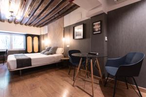 sypialnia z łóżkiem, stołem i krzesłami w obiekcie Suites You Zinc w Madrycie