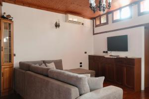 a living room with a couch and a flat screen tv at Old Bazaar House in Krujë