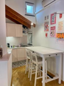 热那亚Carabaghe Style - attico Genova centro storico - acquario - rolli - caruggi - wifi - smart working的白色的厨房，配有白色的桌子和椅子
