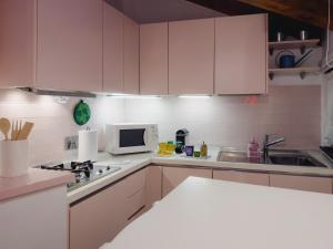 热那亚Carabaghe Style - attico Genova centro storico - acquario - rolli - caruggi - wifi - smart working的厨房配有白色橱柜、水槽和微波炉