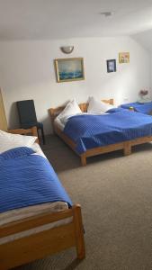 ラシュノフにあるPensiunea Casa Munteanu Râșnovのベッドルーム1室(ベッド2台、椅子付)