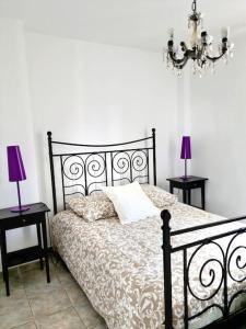 1 dormitorio con 1 cama negra con 2 mesas y 2 lámparas en LES SABLETTES LES PIEDS dans L'EAU, en La Seyne-sur-Mer