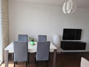 a dining room with a white table and chairs at LES SABLETTES LES PIEDS dans L'EAU in La Seyne-sur-Mer
