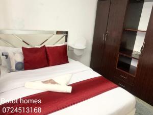 a bedroom with a large bed with red pillows at Rorot Spacious one bedroom in Kapsoya with free Wifi in Eldoret