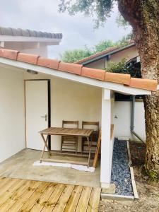 a patio with a table and a tree at Sous deux chênes in Vieux-Boucau-les-Bains