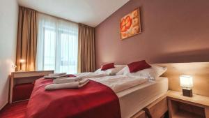 a bedroom with a large bed with a red blanket at Hotel Crocus in Vysoke Tatry - Strbske Pleso