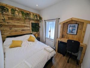 a bedroom with a bed and a chair and a window at Stylish House in Welsh Hills, Sleeps 8 to 12 in Rhondda