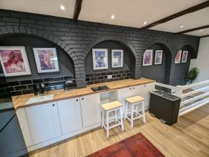 a kitchen with a counter and a brick wall at Stylish House in Welsh Hills, Sleeps 8 to 12 in Rhondda