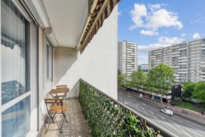 2 stoelen op een balkon met uitzicht op een straat bij Chic and comfortable apart with balcony in Levallois-Perret