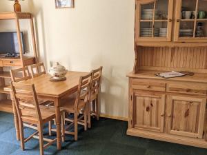 a dining room with a wooden table and wooden cabinets at Charmant 2 pièces au pied des pistes avec balcon et casier à skis - FR-1-557-59 in Les Adrets +3 photos