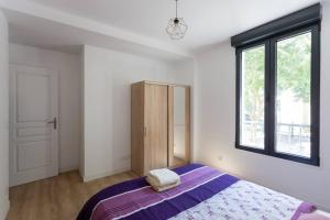 a bedroom with a large bed and a window at Superbe maison proche de Paris! in Sceaux