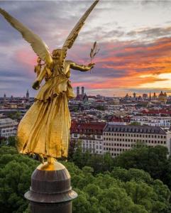 uma estátua de um anjo com uma cidade ao fundo em Jezza Apart Suite em Munique