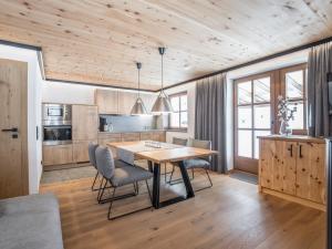 een keuken met een houten plafond en een tafel en stoelen bij Appartementhaus Trixl in Fieberbrunn