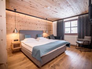 een slaapkamer met een groot bed en een houten plafond bij Appartementhaus Trixl in Fieberbrunn