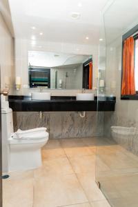 y baño con aseo, 2 lavabos y espejo. en Hotel Brisa en Punta Cana