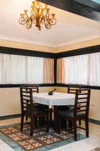 comedor con mesa, sillas y lámpara de araña en Hotel Brisa en Punta Cana