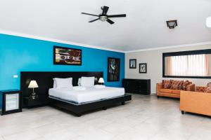 1 dormitorio con cama y pared azul en Hotel Brisa en Punta Cana